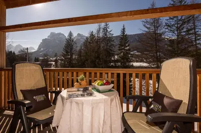 a table with a bowl of fruit on a porch at Hotel Rezia in La Villa