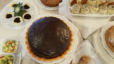 a chocolate cake on a table with other desserts at Hotel Vienna in San Martino di Castrozza