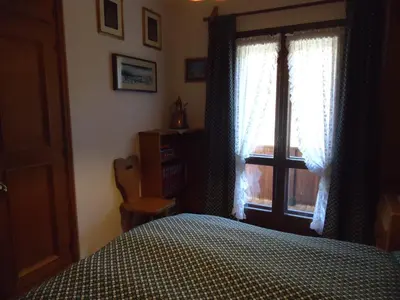 a bedroom with a bed and a window at Sweet Home in Cortina dʼAmpezzo