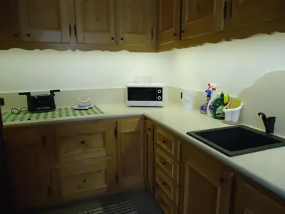 a kitchen with a sink and a microwave on a counter at Sweet Home in Cortina dʼAmpezzo
