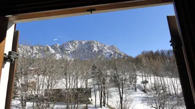 a view of a snowy mountain from a window at Sweet Home in Cortina dʼAmpezzo