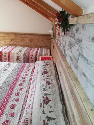 two beds in a room with a brick wall at Agritur le Vale in Fiera di Primiero