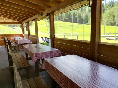 a row of tables and benches in a restaurant at Agritur le Vale in Fiera di Primiero
