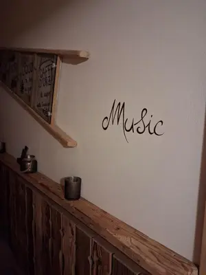 a sign on a wall with the word music on it at Majon de la nona in Pozza di Fassa