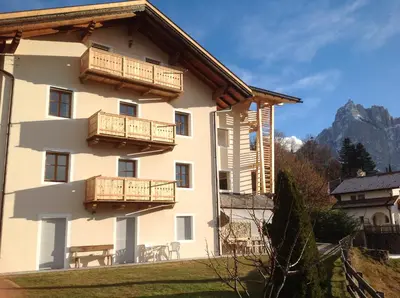 a building with wooden balconies on the side of it at Villa Tannenheim in Castelrotto