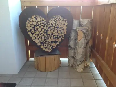 a heart made out of wood sitting on a stump at Villa Tannenheim in Castelrotto