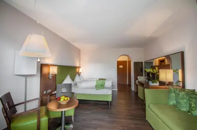 a hotel room with a bed and a couch at Christophs Hotel in Schenna