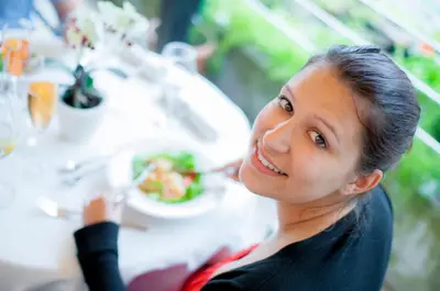 a woman sitting at a table eating food at Christophs Hotel in Schenna