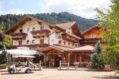 a building with a car parked in front of it at Hotel El Mondin in Fiera di Primiero