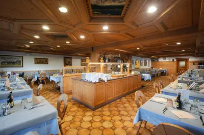 a restaurant with blue tables and chairs and a buffet at Berg Hotel Latemar Spitze in Vigo di Fassa