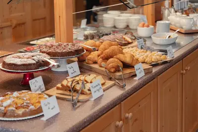 a buffet filled with different types of bread and pastries at Berg Hotel Latemar Spitze in Vigo di Fassa
