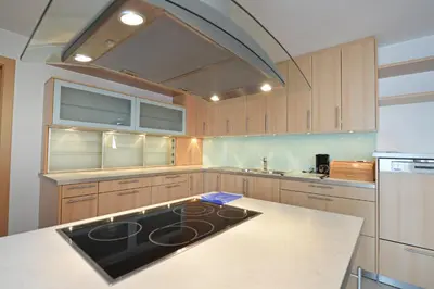 a kitchen with wooden cabinets and a stove top oven at Villa sulla passeggiata in Ortisei