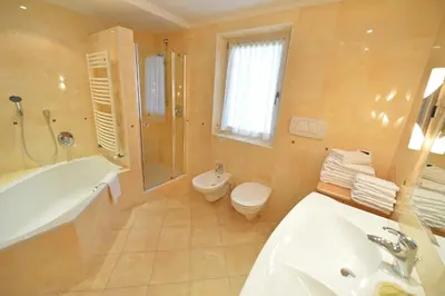 a bathroom with a tub and a toilet and a sink at Villa sulla passeggiata in Ortisei