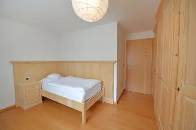 a bedroom with a bed and a wooden floor at Villa sulla passeggiata in Ortisei