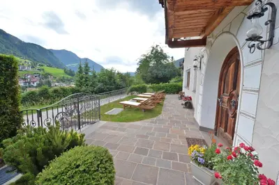 a balcony of a building with a table and benches at Villa sulla passeggiata in Ortisei