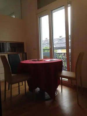 a table and chairs in a room with a window at Apartment G.Verdi in Bolzano
