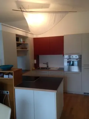 a kitchen with white cabinets and a light on the ceiling at Apartment G.Verdi in Bolzano