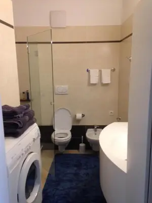 a bathroom with a toilet and a sink and a washing machine at Apartment G.Verdi in Bolzano