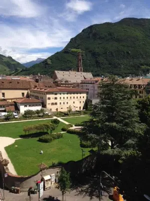a city with a green park in front of a mountain at Apartment G.Verdi in Bolzano