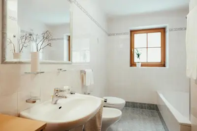 a white bathroom with a sink and a toilet at Ciasa Pedaga in San Vigilio Di Marebbe