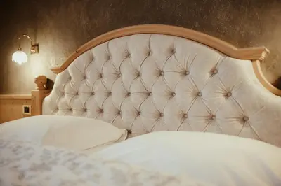 a close up of a bed with a large headboard at Ciasa Pedaga in San Vigilio Di Marebbe