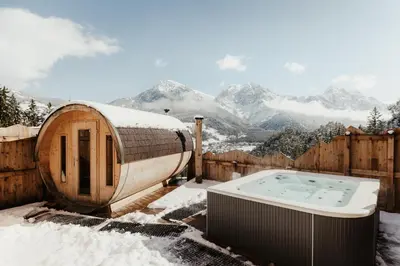 a hot tub sitting on top of a snow covered yard at Ciasa Pedaga in San Vigilio Di Marebbe