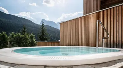 a jacuzzi tub with a water fountain at Hotel La Fradora - Dolomites Hotel in San Cassiano