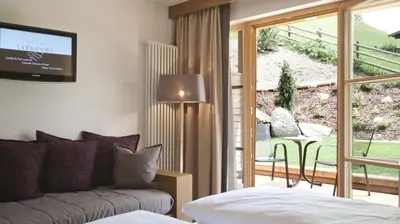 a hotel room with a bed and a desk at Hotel La Fradora - Dolomites Hotel in San Cassiano