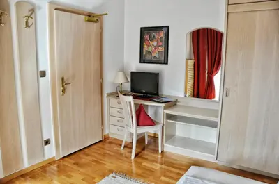 a room with a desk with a computer and a chair at Hotel Brunner in Merano