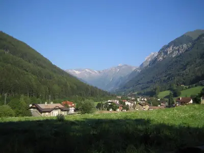 a village in a valley with mountains in the background at Hotel Schuster in Colle Isarco