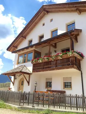 a house with a balcony with flowers on it at Sumaela Apartments in La Valle