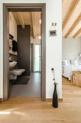 a room with a bedroom with a bed and a vase with flowers at B&B Lupo in Cavareno