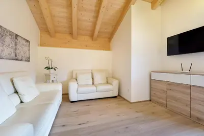 a table and chairs on a balcony with a view of mountains at Appartamenti Casa Salesai in Carano