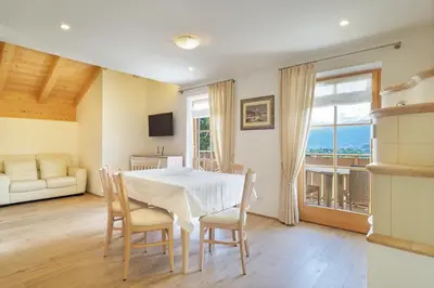 a kitchen and dining room with a table and a refrigerator at Appartamenti Casa Salesai in Carano