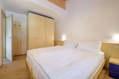 a living room with a white couch and a tv at Appartamenti Casa Salesai in Carano