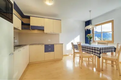 a kitchen and dining room with a table and chairs at Appartamenti Casa Salesai in Carano