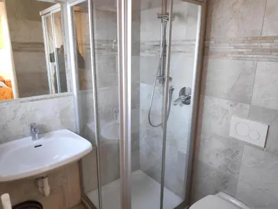 a bathroom with a shower and a toilet and a sink at Plonerhof - Ferienhaus Maria in Rodengo
