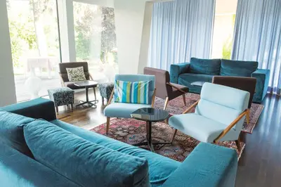 a room with a table and a chair and green wall at Azalea Park Hotel in Cavalese