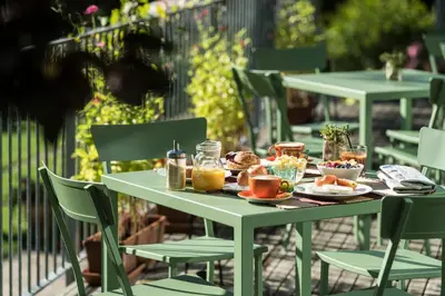 a table topped with plates of breakfast foods and coffee at Azalea Park Hotel in Cavalese