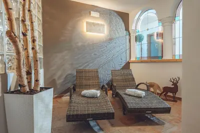 a room with two chairs and a wall with a mural at Aparthotel Majestic in Predazzo