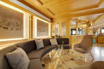 a living room with a couch and a glass table at Aparthotel Majestic in Predazzo
