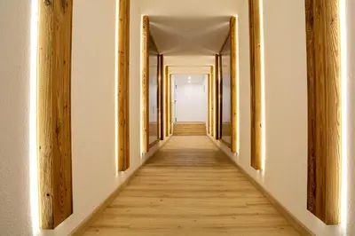 an empty corridor with wooden floors and a door at Residence Lagorai in Tesero