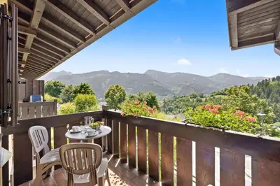 a balcony with a table and chairs and mountains at Residence Lagorai in Tesero