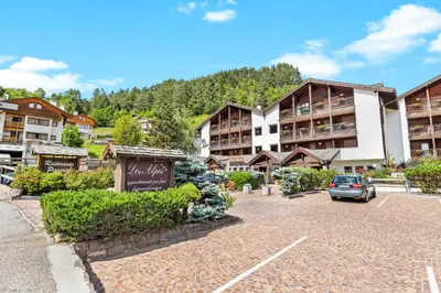a parking lot in front of a resort at Aparthotel Des Alpes in Cavalese