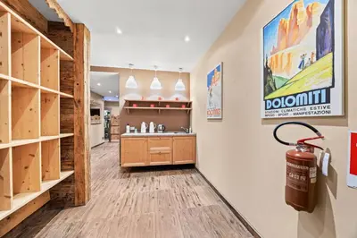a sauna with wooden walls and a glass door at Aparthotel Des Alpes in Cavalese