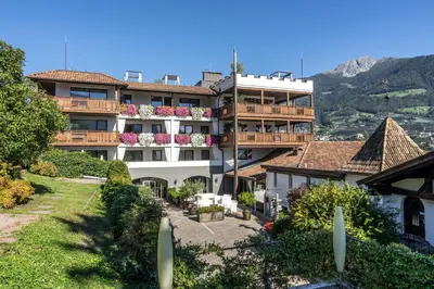a hotel with a balcony with flowers on it at Golserhof in Tirolo