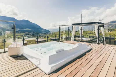 a hot tub on a deck with a view of a mountain at Golserhof in Tirolo
