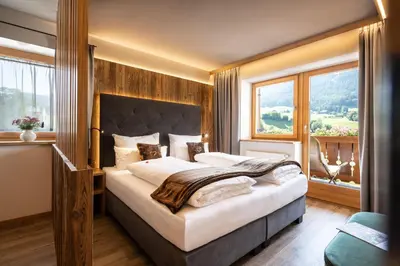a bedroom with a large bed and a large window at Appartements Plattnerhof in Castelrotto