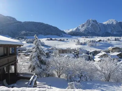 a village covered in snow with mountains in the background at Appartements Plattnerhof in Castelrotto