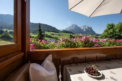 a room with a window with a table and flowers at Appartements Plattnerhof in Castelrotto